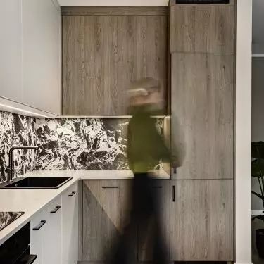 Wooden cabinetry adds warmth to the black-and-white kitchen