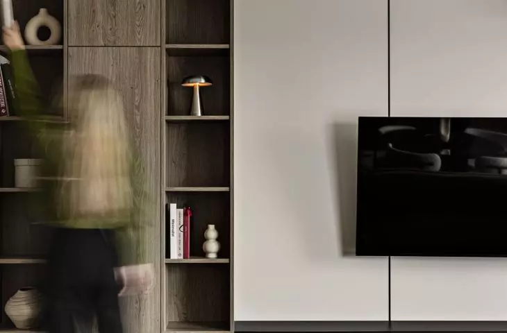 The living room furniture features a combination of open shelves, cabinets, and a space for the TV