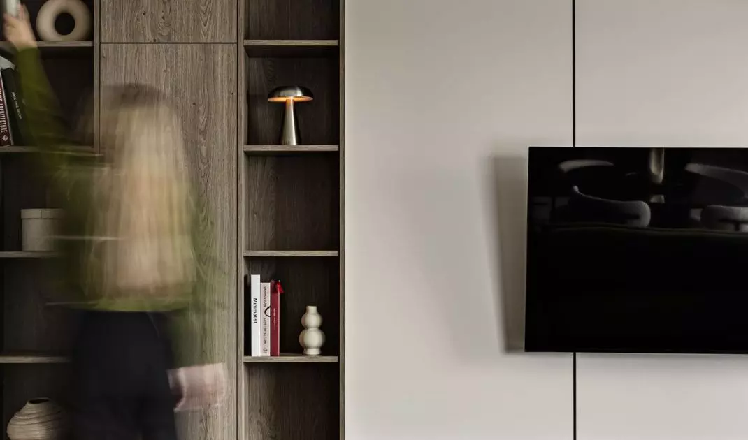 The living room furniture features a combination of open shelves, cabinets, and a space for the TV