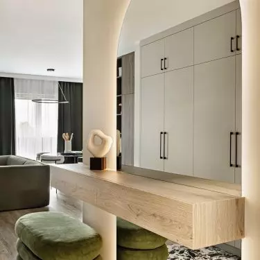 Patterned tiles define the entryway, and the green ottomans complement the living room's color scheme