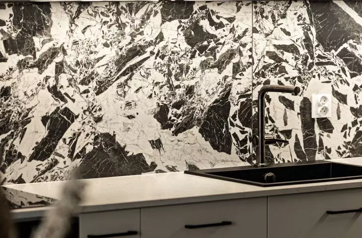 A striking stone pattern breaks up the smooth kitchen cabinet fronts