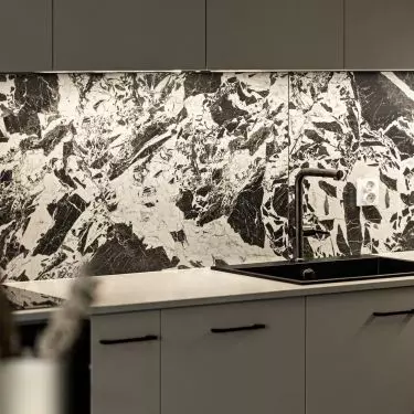 A striking stone pattern breaks up the smooth kitchen cabinet fronts