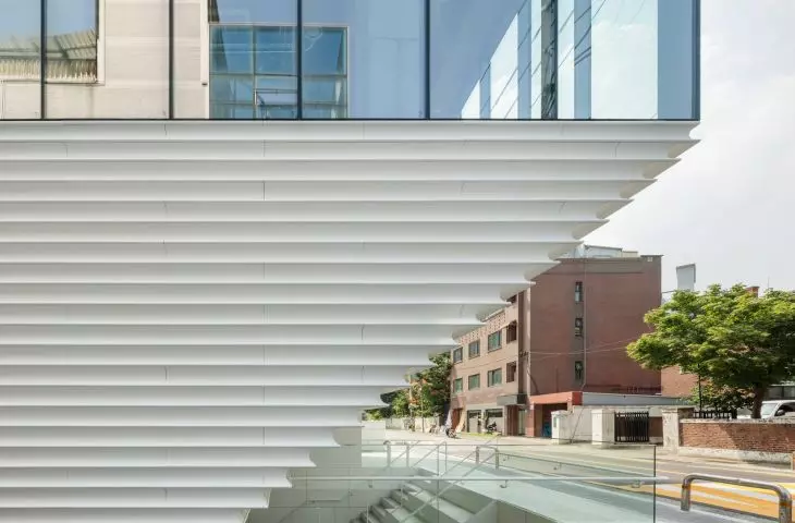 The white facade of the Hapjeong Artplex is composed of horizontal, profiled panels