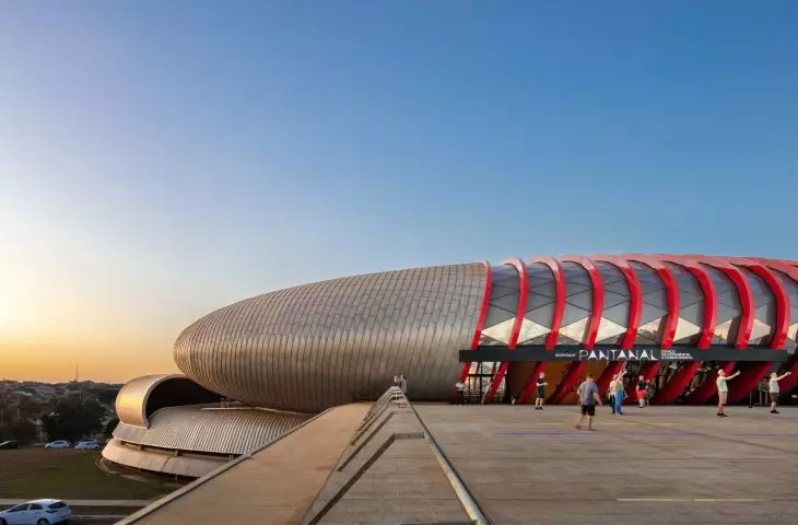 The elliptical structure rises above the ramp leading to the entrance