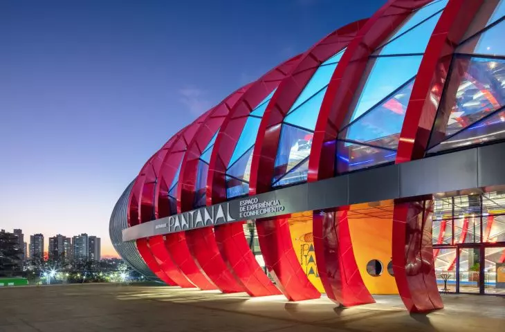 The red structural ribs set the rhythm of the glass facade