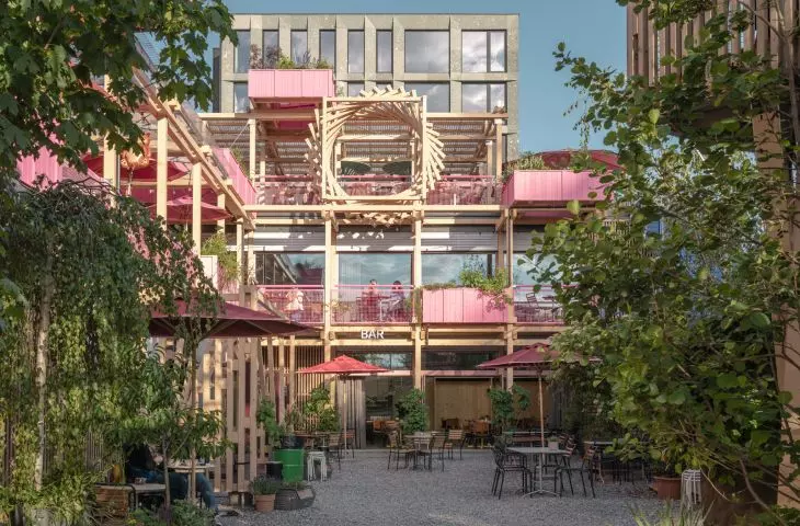 Drewniana konstrukcja i różowe detale wyróżniają Remise Rosa na tle otaczającej zabudowy