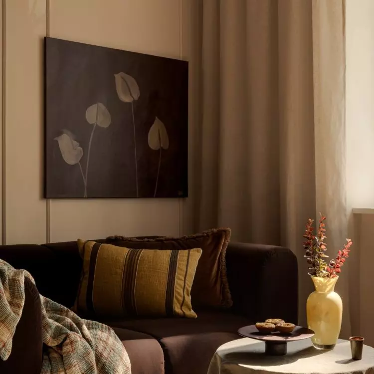 The living room's warm color scheme is complemented by a painting created by the future resident