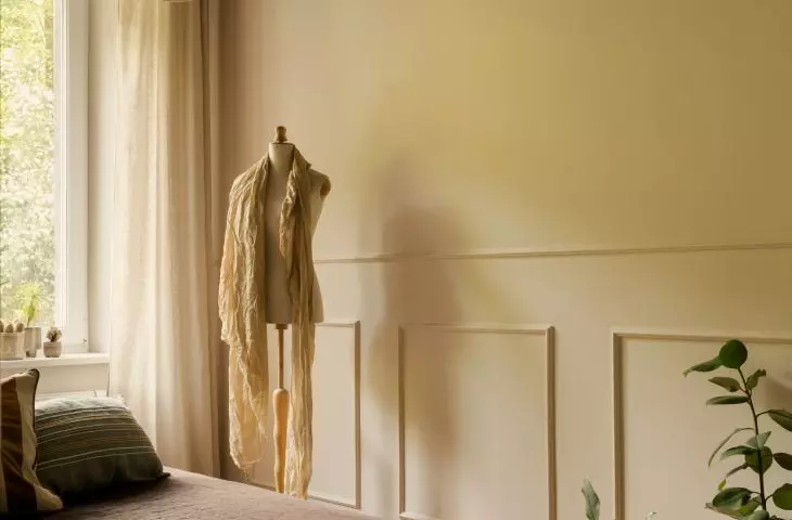 The dark ceiling in the bedroom contrasts with the light-colored walls and the view of the greenery