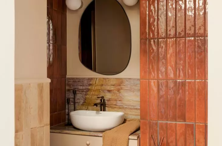 In the bathroom, glazed tiles are paired with stone featuring a distinctive pattern
