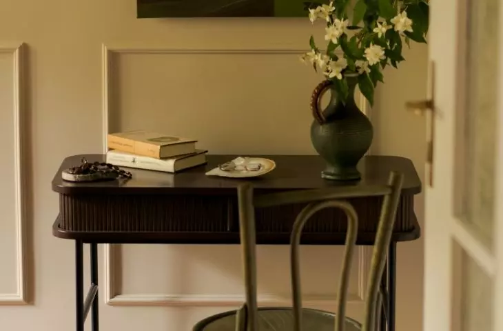 The small desk creates a space for studying, and the painting created by the resident gives it a personal touch