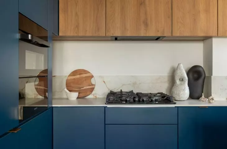 The navy blue kitchen served as the starting point for the color scheme of the entire apartment