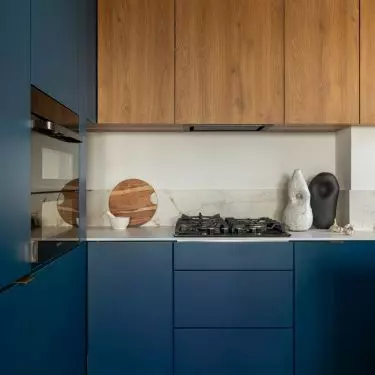 The navy blue kitchen served as the starting point for the color scheme of the entire apartment