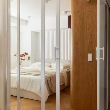 Sliding glass doors separate the bedroom without blocking the light