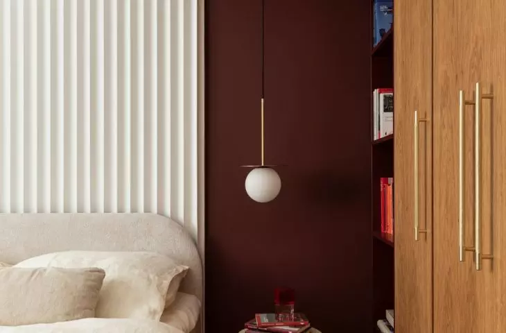 The burgundy alcove emphasizes the intimate character of the sleeping area