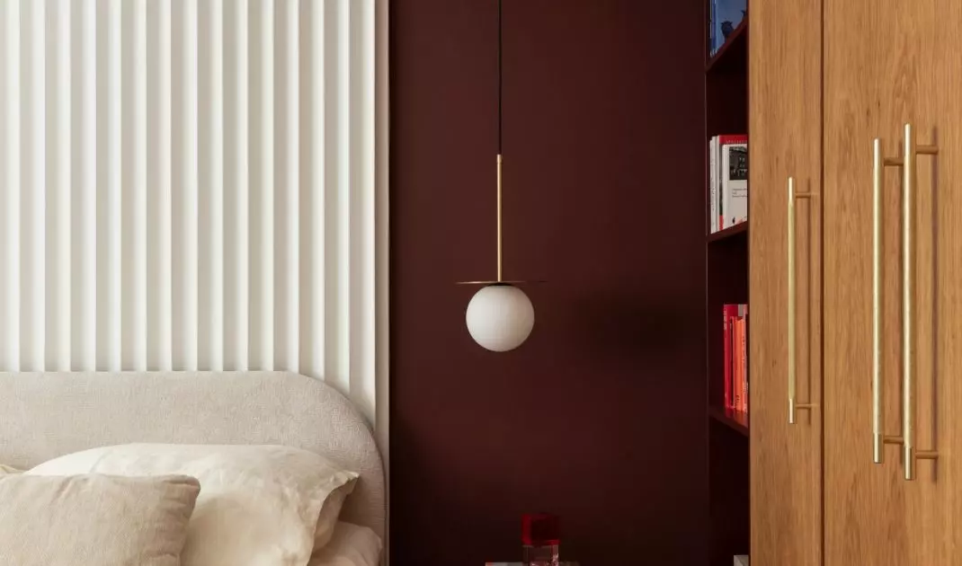 The burgundy alcove emphasizes the intimate character of the sleeping area