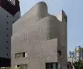The nearly enclosed concrete facade gives the building the appearance of a protective shell 