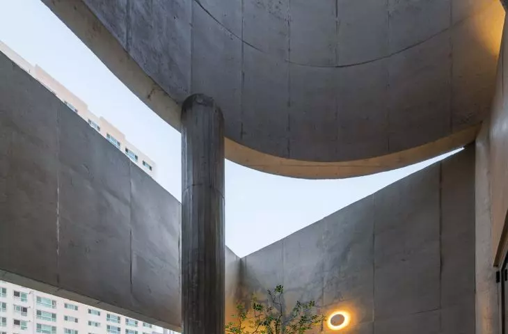 Betonowe ściany tarasu kadrują widoki na niebo i zabudowę Busan