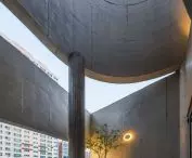 Betonowe ściany tarasu kadrują widoki na niebo i zabudowę Busan