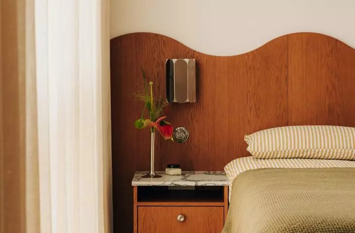 The wavy line of the wooden headboard gives this serene bedroom a distinctive character