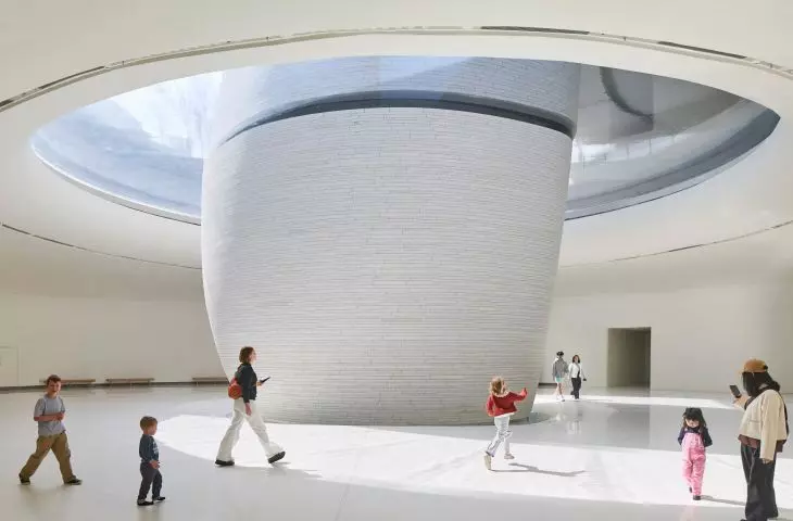 The curved walls and the light streaming in from above define the interior of one of the atria