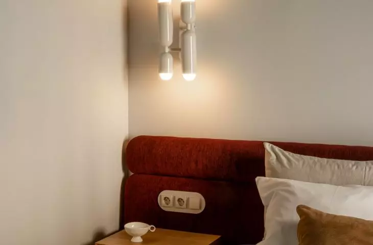 The navy blue ceiling and burgundy headboard create an intimate atmosphere in the bedroom