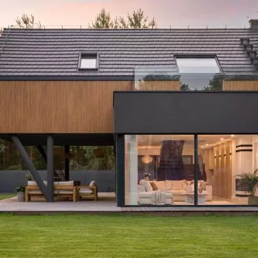 The glass-enclosed living room opens onto the terrace and the pine forest surrounding the house