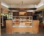 The centerpiece of the interior is a large counter displaying a selection of baked goods