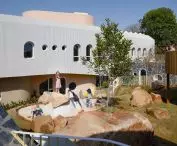 A garden with boulders, sand, and varied terrain encourages children to play freely and explore their surroundings