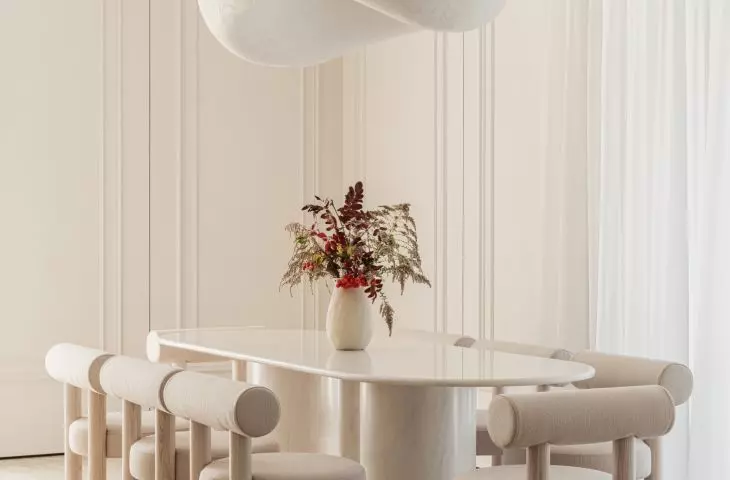 A monumental lamp resembling a cloud hung above the stone table