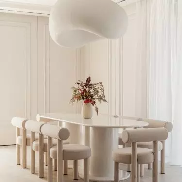 A monumental lamp resembling a cloud hung above the stone table