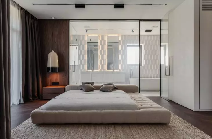 The bathroom is separated from the master bedroom by smart glass that can become transparent or frosted