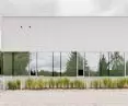 The expansion of the Physical Education and Sports Center in Łódź features a light, minimalist structure