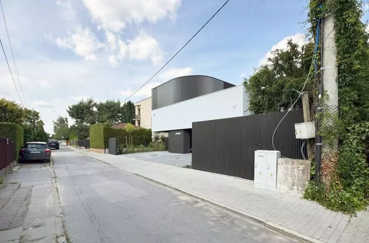 jednym z wyzwań była lokalizacja przy wąskiej ulicy dojazdowej. Dzięki rezygnacji z ogrodzenia, przestrzeń zyskała oddech