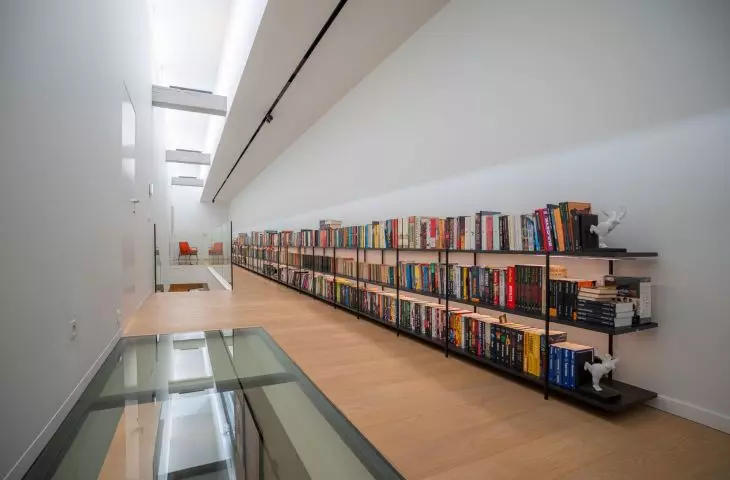 Light from the skylight illuminates the upstairs hallway, and thanks to the glass floors, it streams into the ground-floor foyer