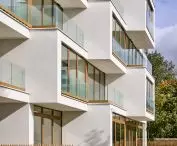 The facade of the dynamic mass, full of large glazing, was finished with light plaster