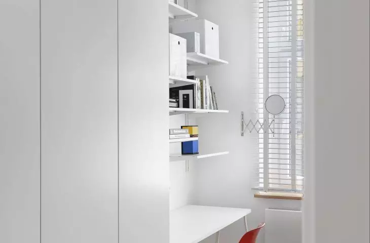 Red chair breaks the white of the room