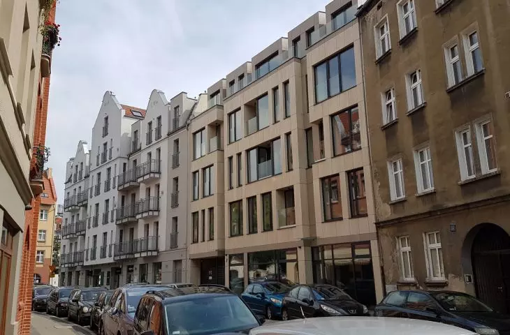 The newest building on Ostrówek Street in Srodka, with tenement houses converted to a hotel in the background