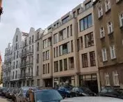 The newest building on Ostrówek Street in Srodka, with tenement houses converted to a hotel in the background