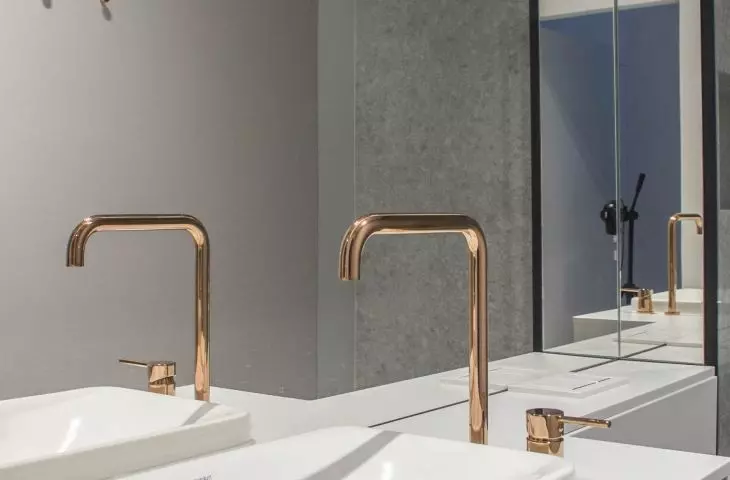 Gold faucets go perfectly with gray tiles