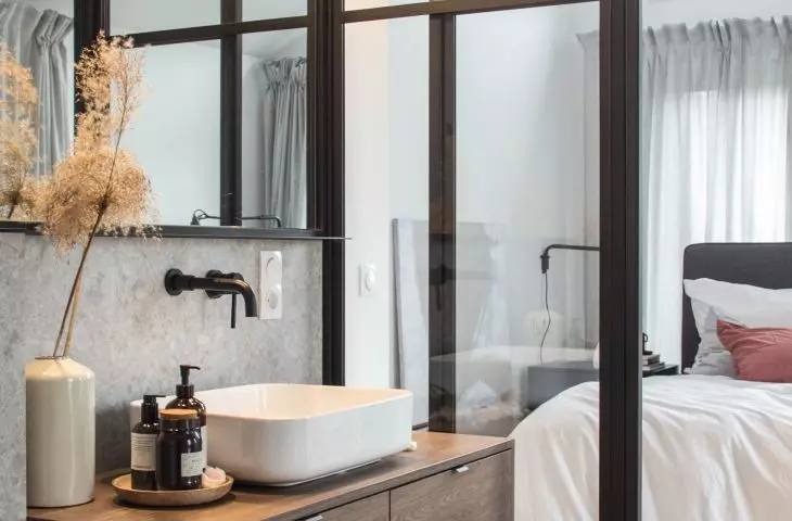 Wooden cabinet warms the gray of the bathroom