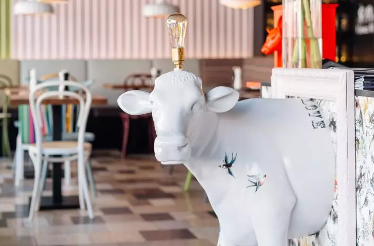 The front of the cow coming out of the picture frame