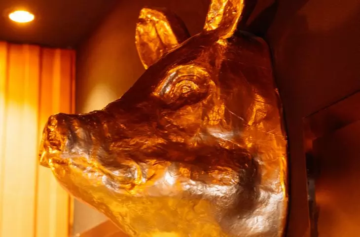 Golden pig's head guards entrance to toilets