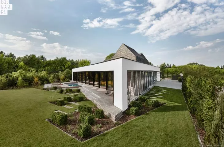 trapezoid-shaped plot of land and the nearby flood embankment determined the unusual shape of the house