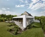 trapezoid-shaped plot of land and the nearby flood embankment determined the unusual shape of the house