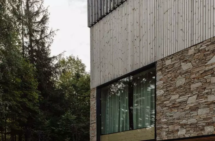 Facade of split gneiss, pine thermo wood and wooden laths