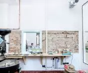 The background for the black stove is made up of white walls, partially exposing the bricks