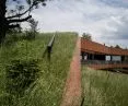 the roof of the corten-clad building is covered by an earthen structure with sod