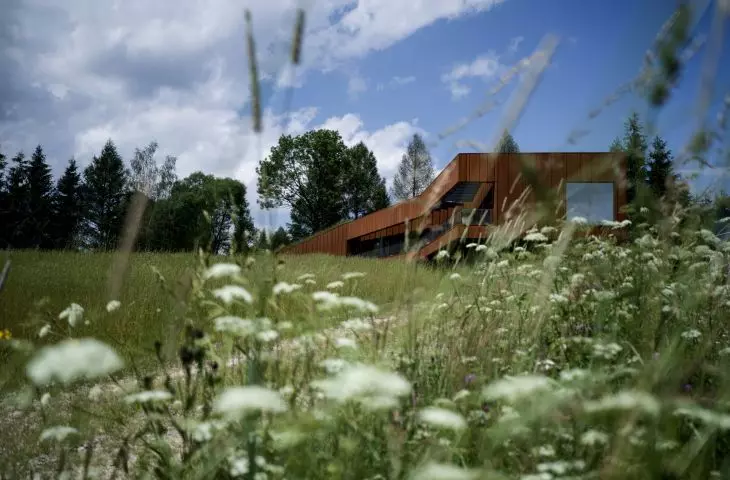 The building frames the view of the Otryt, which is reflected in places on the glazing of the facade