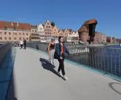 Strollers on the rotary footbridge against the background of the old town and the crane on Dlugi Pobrzeze Street 