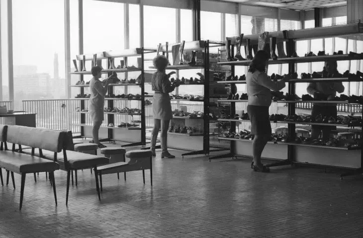 A fragment of the interior of the store. Female employees arrange goods on shelves